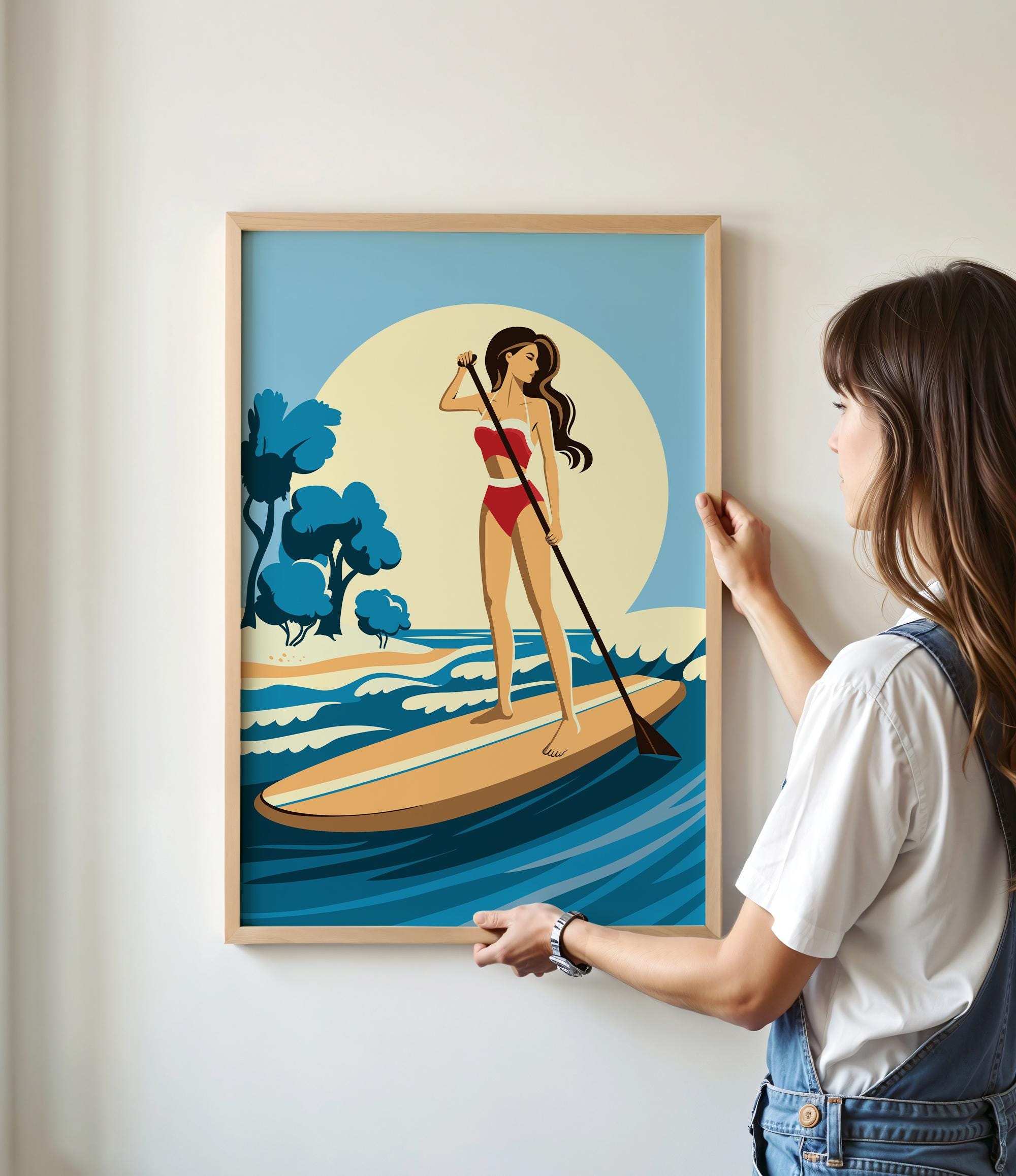 A woman is standing on a surfboard and holding a paddle, with a beach scene in the background.