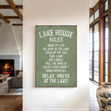 a sign that reads "LAKESHOUSE RULES" hanging on a wall in a room with a fireplace and a vase.