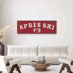 a living room with a white sofa and two chairs. Above the sofa, there is a red sign with the text "APRES SKI" and some icons representing drinks and a snowflake.