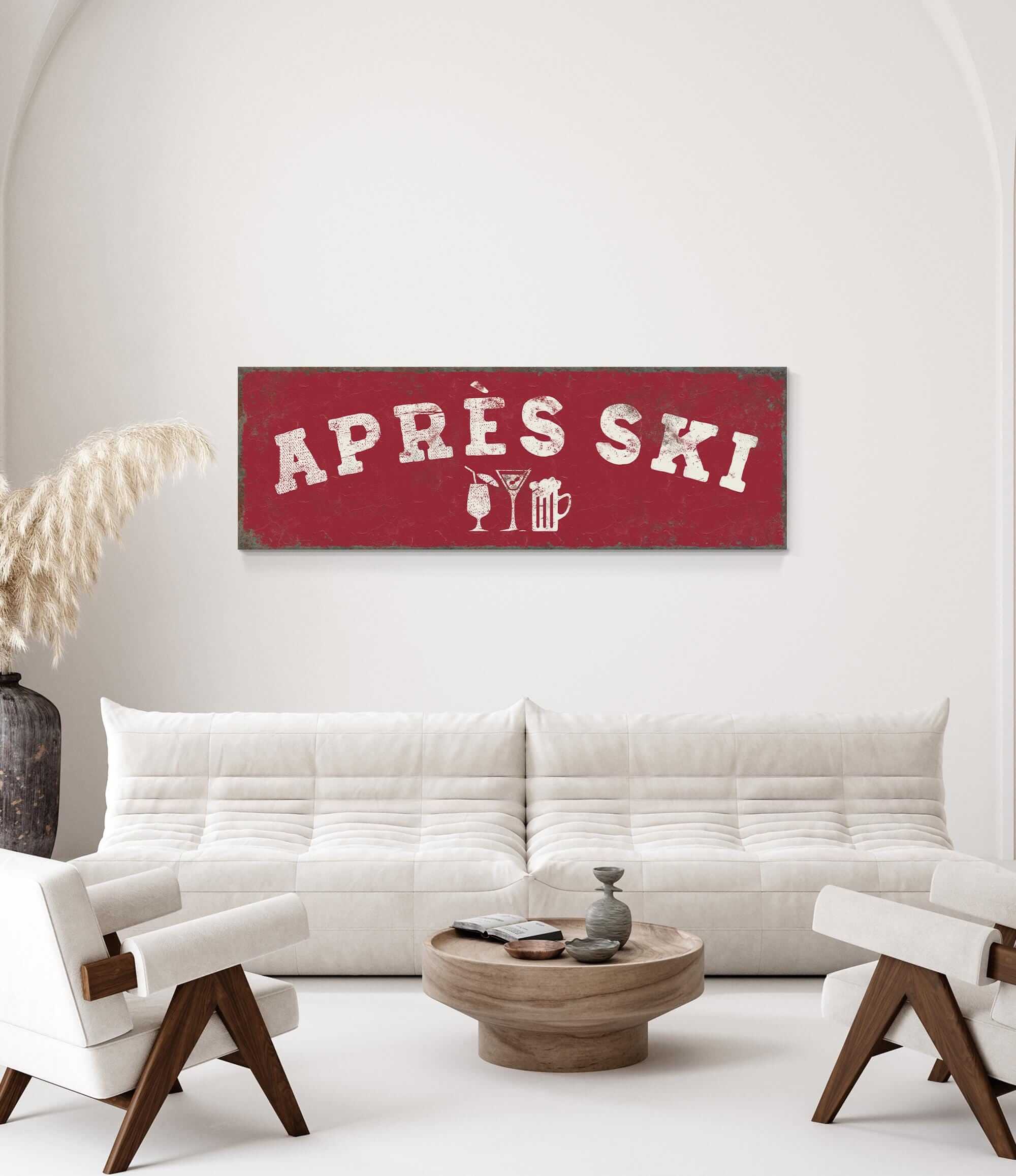 a living room with a white sofa and two chairs. Above the sofa, there is a red sign with the text "APRES SKI" and some icons representing drinks and a snowflake.