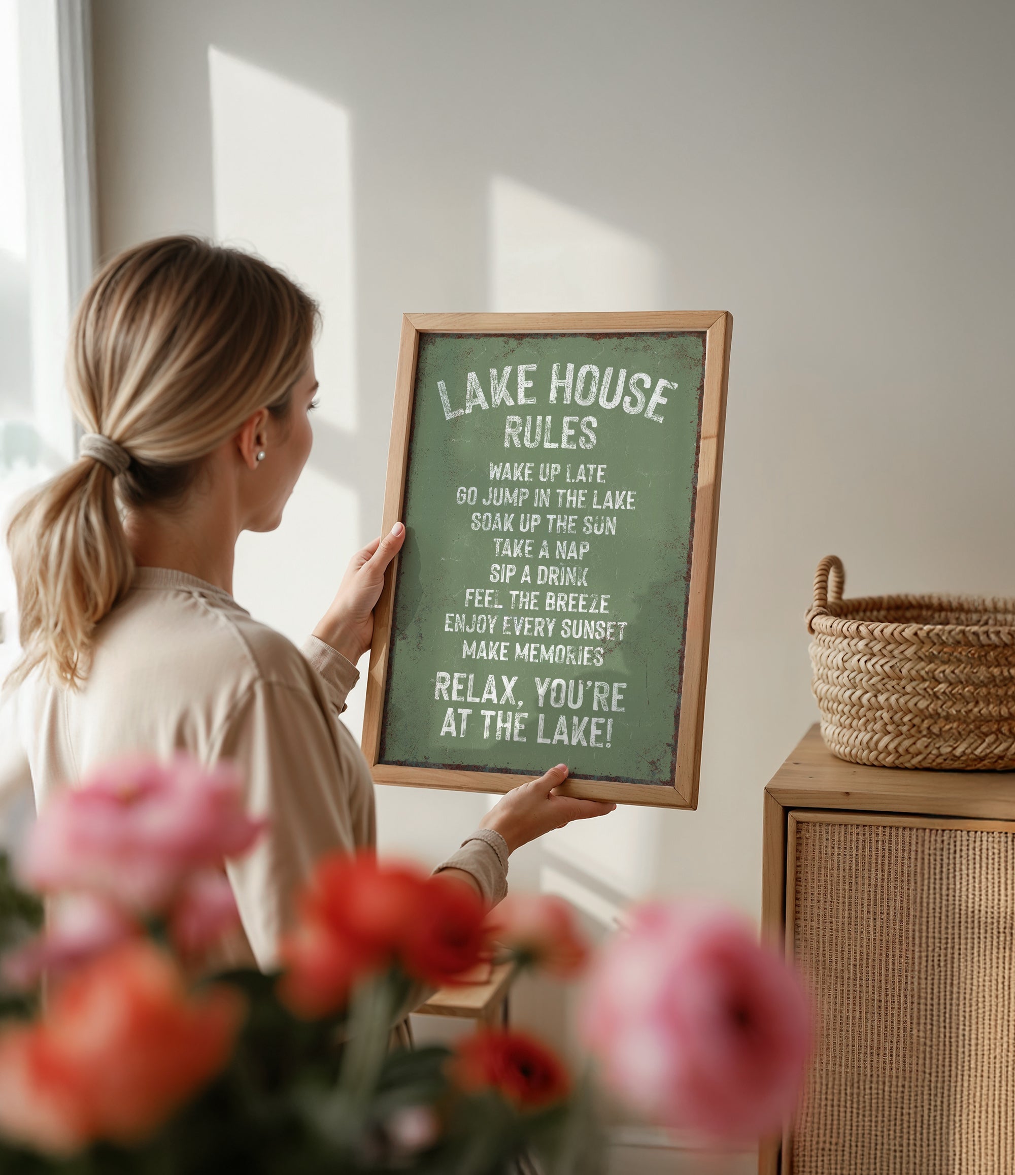 A woman is holding a framed sign with a list of rules for the Lake House, including guidelines for visitors to follow.