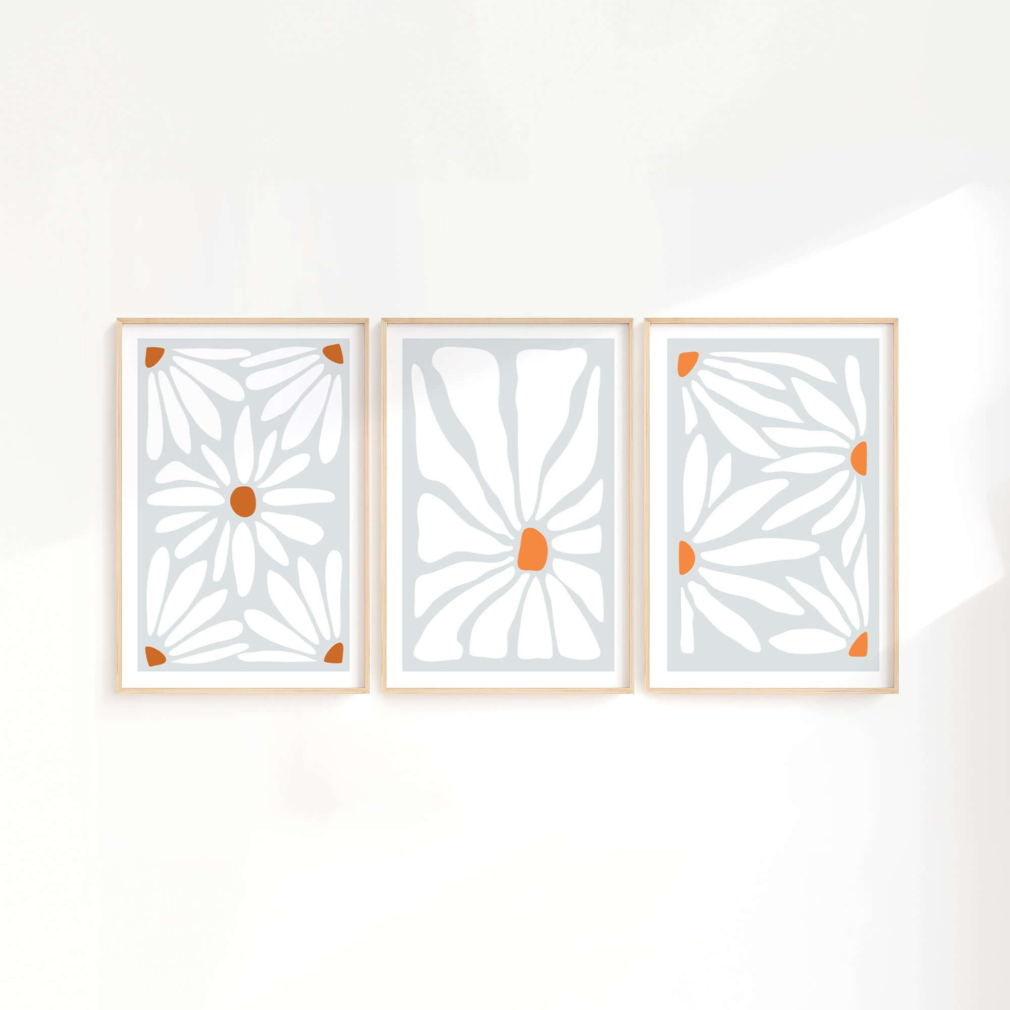 The Flower Blocks Triptych | Set of Three Prints | 014 features abstract floral designs in orange and white, elegantly framed in wood—perfect wall art to elevate your home decor.