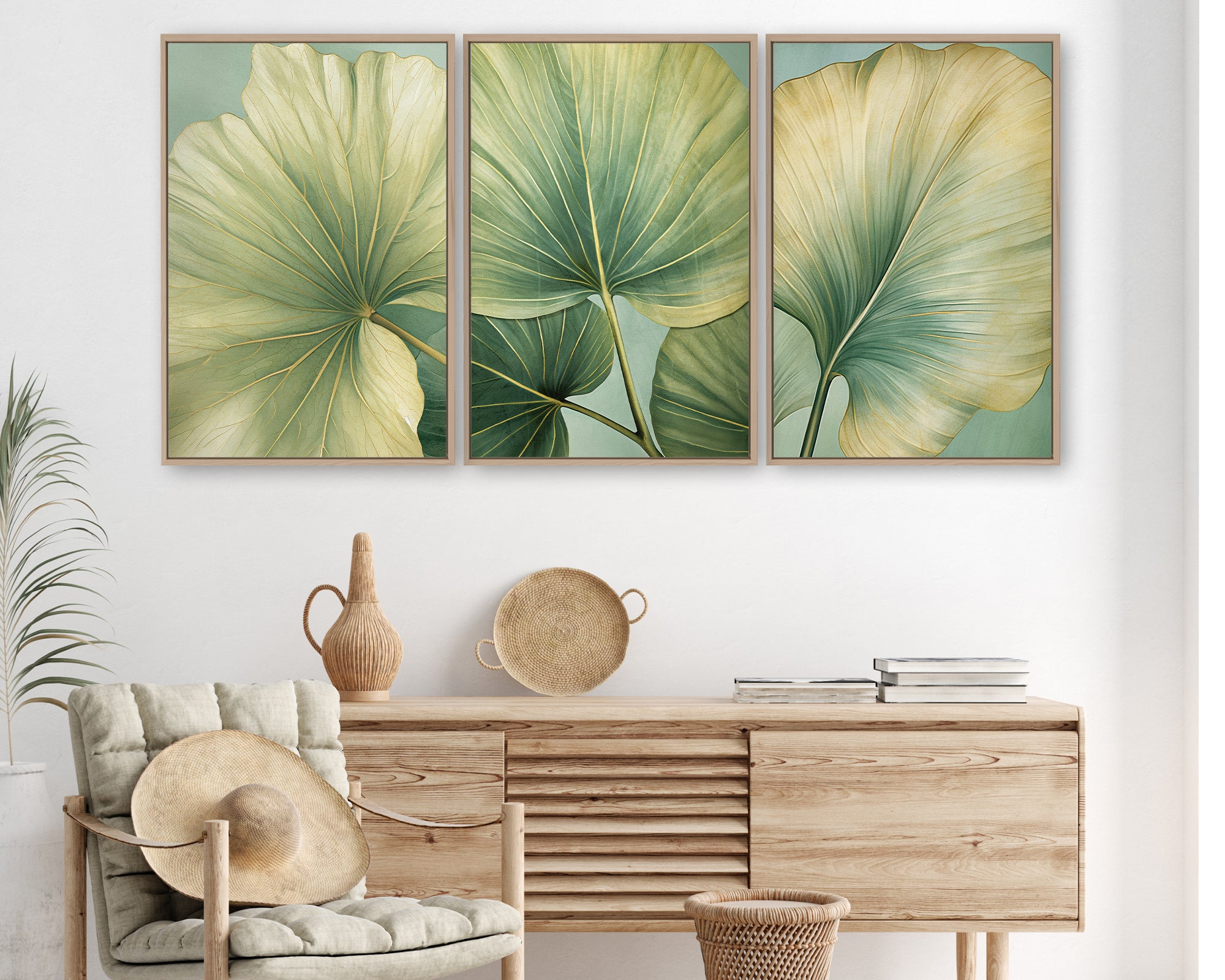 a living room with a wooden dresser, a woven basket, and a woven chair. Above the dresser, there are three framed prints of large green leaves on a white wall.