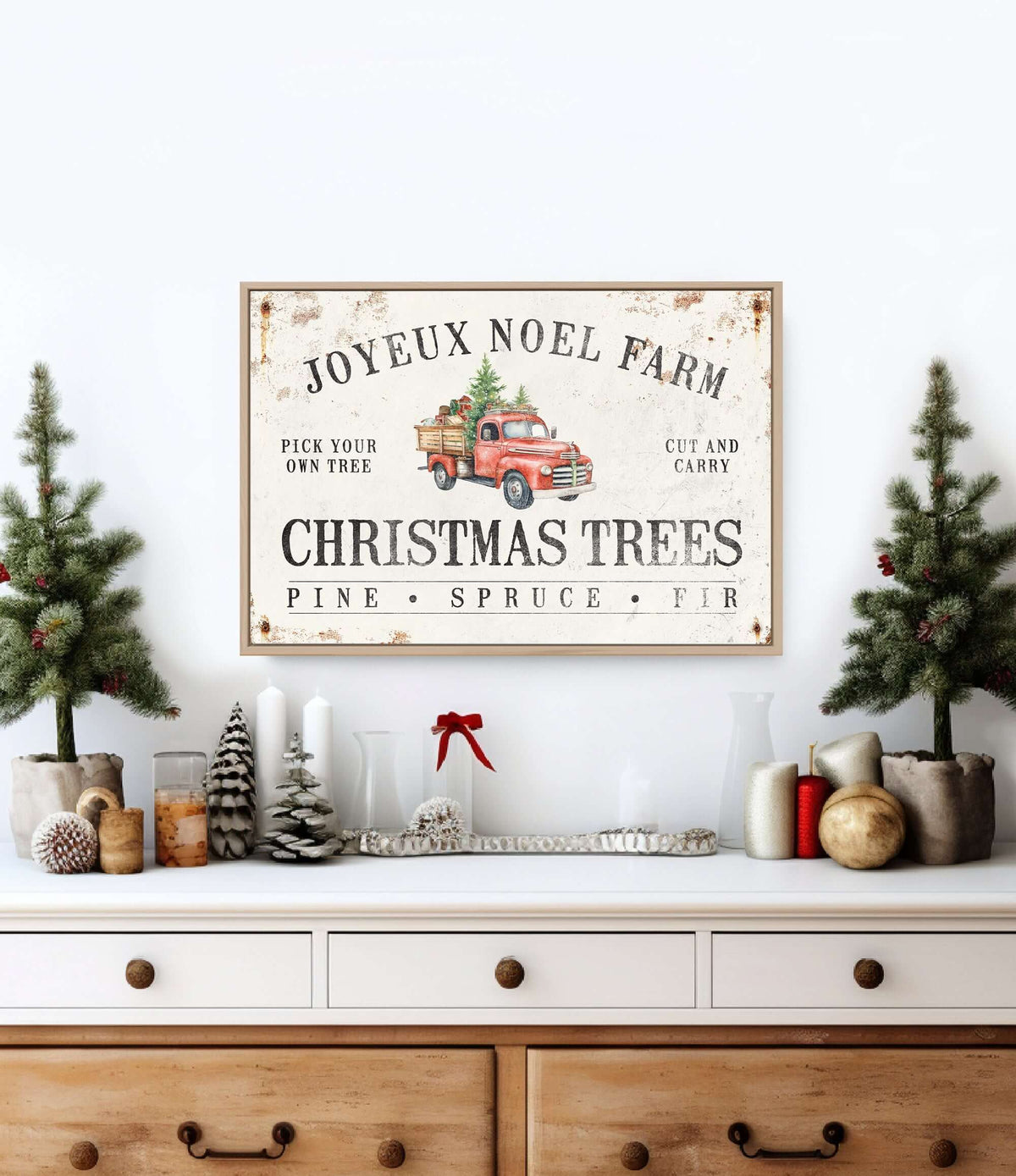 a christmas tree sits on a dresser next to a sign