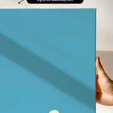 The image is a hand holding a blue canvas print with a white line running across it.
