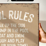 a hand holding a sign that says pool rules
