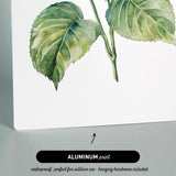 The image is an aluminum print featuring a watercolor painting of a green leaf and a purple flower.