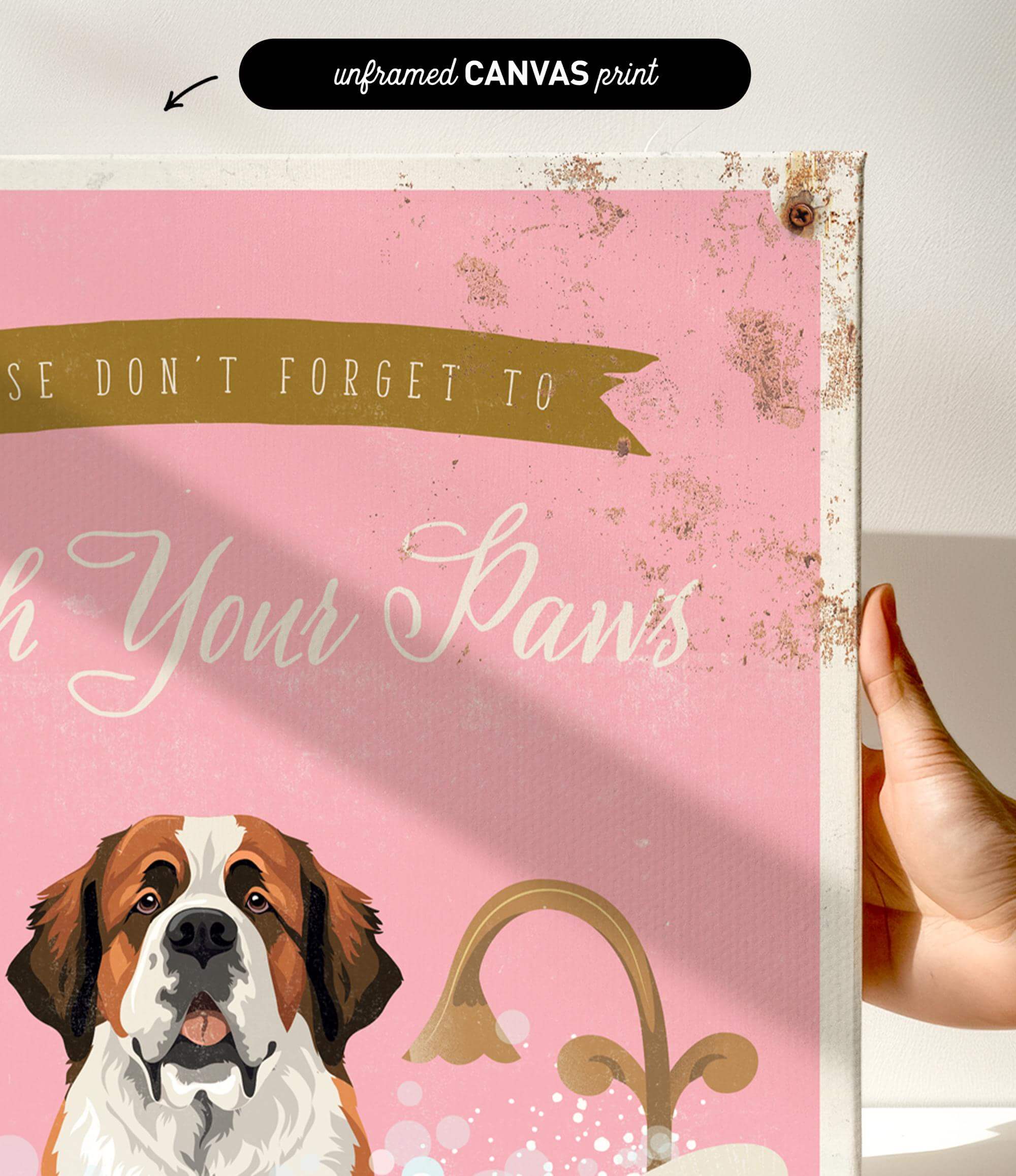 a hand holding a framed print with a dog's face and the text "Don't forget to wash your paws" on it.