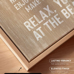 a close-up view of a wooden frame with a canvas print on it. The text on the canvas print reads "HAPPY HAVE ENJOY ME MAKE YOU MAKE AT THE BEACH". The text is in white and is located on the wooden frame.