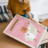 A woman is holding a framed poster with a dog in a bathtub, and the poster has a pink background with a message about washing dogs.