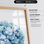 a framed print of a blue flower arrangement, with a natural frame.