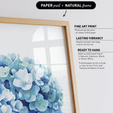 a framed print of a blue flower arrangement, with a natural frame.
