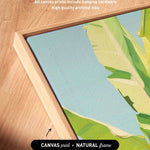 a close-up view of a framed artwork with a vibrant green and yellow tropical plant depicted on the canvas.