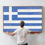 a man standing in front of a painting of the flag of greece