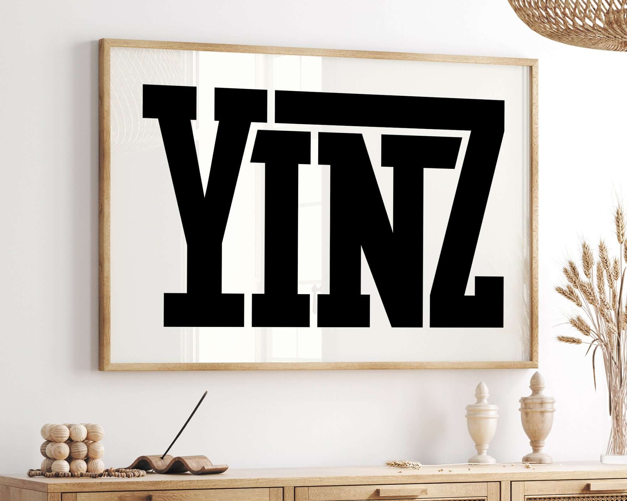The Yinz Sign Print in off white adds playful charm and a bold statement to modern farmhouse decor, displayed above a wooden sideboard in a neutral-toned room.