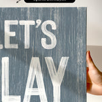 a hand holding a sign that says let&#39;s play