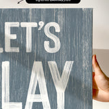 a hand holding a sign that says let&#39;s play