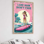 a framed poster with a woman paddleboarding on a lake, with the text "LAKES DON'T CARE" written above her.