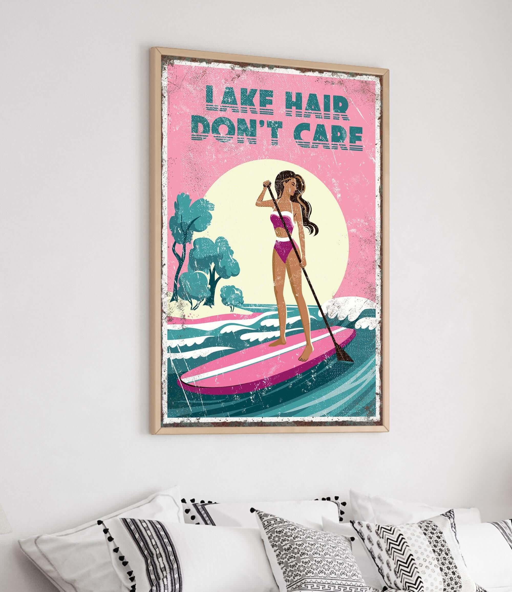 a framed poster with a woman paddleboarding on a lake, with the text "LAKES DON'T CARE" written above her.