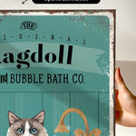 a hand holding a sign that says ragdol and bubble bath co