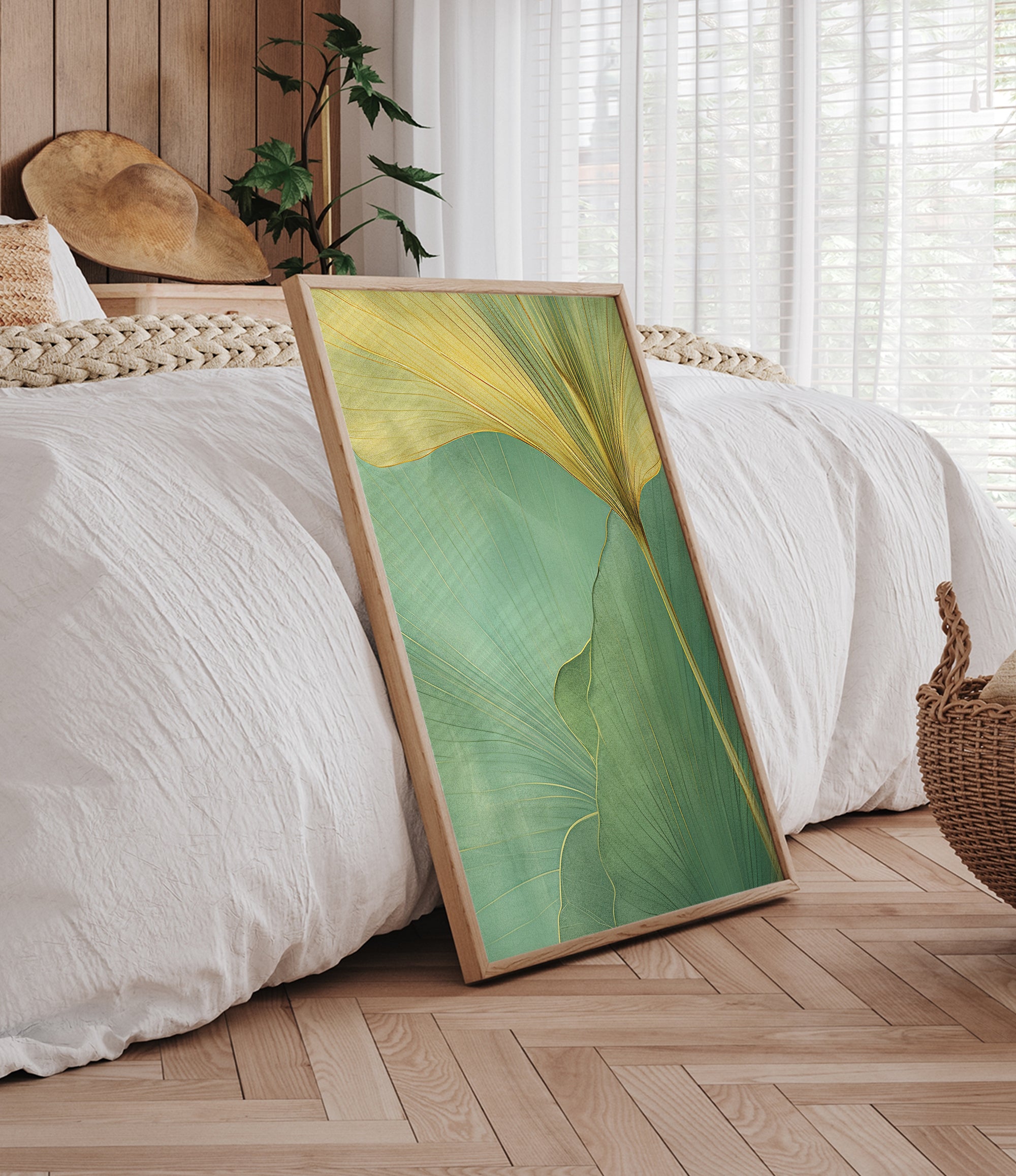 a large framed print of a green leaf with yellow lines, placed on a wooden floor in a bedroom setting.