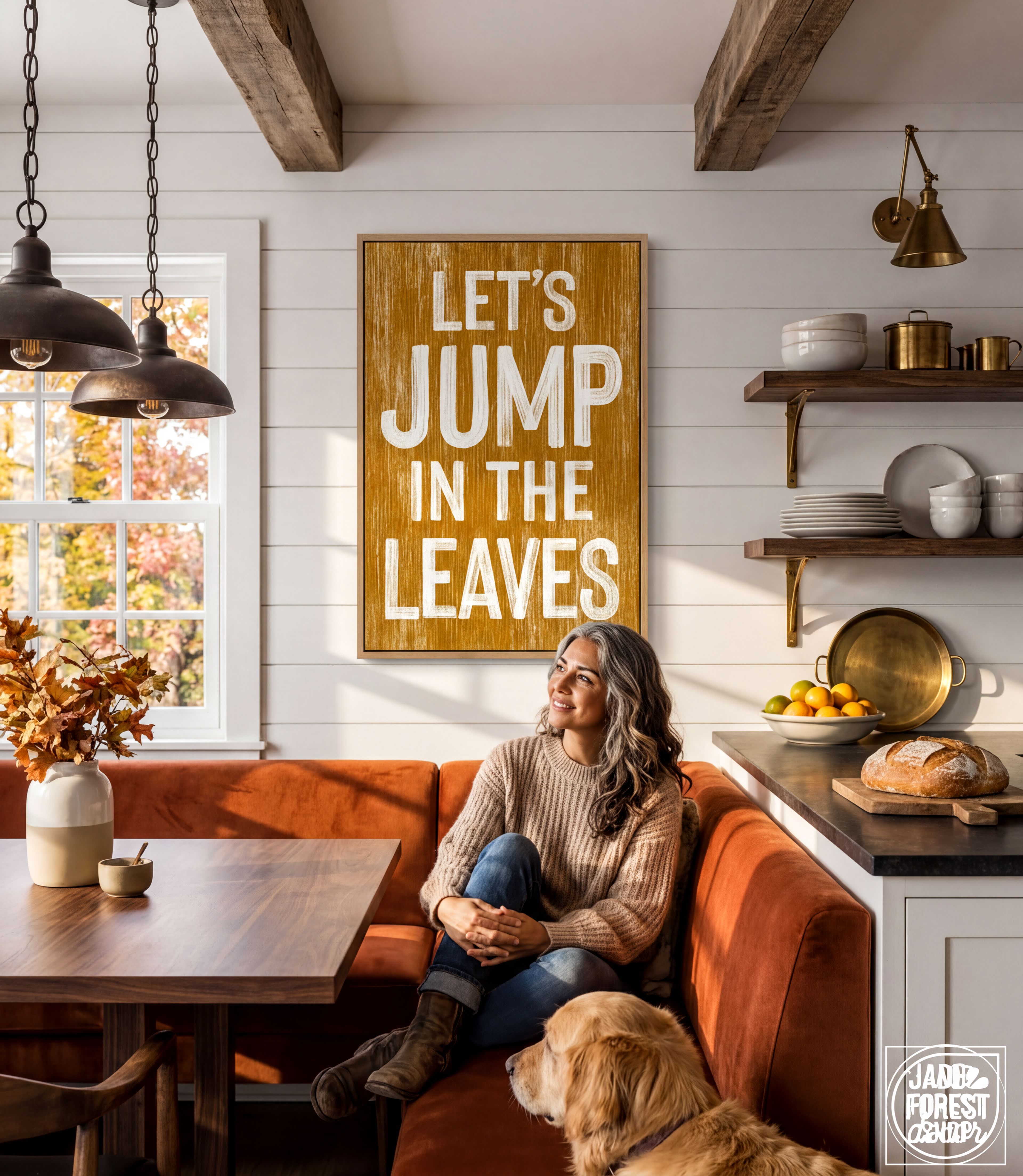 A woman sits on a red couch in a cozy kitchen, with a wooden sign above her that reads "Let's JUMP IN THE LEAVES".
