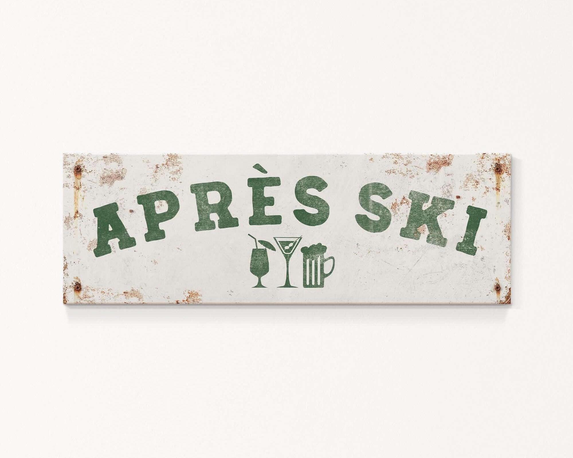 A weathered sign with the text "APRES SKI" in green letters, along with icons of a beer glass and a martini glass, indicating a location or establishment related to skiing and alcoholic beverages.