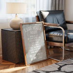 a framed sign with a humorous message about lake rules, placed on a wooden floor next to a black leather chair and a lamp.