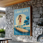 A framed poster of a woman paddleboarding on a lake, with the text "LAKELIFE" prominently displayed.