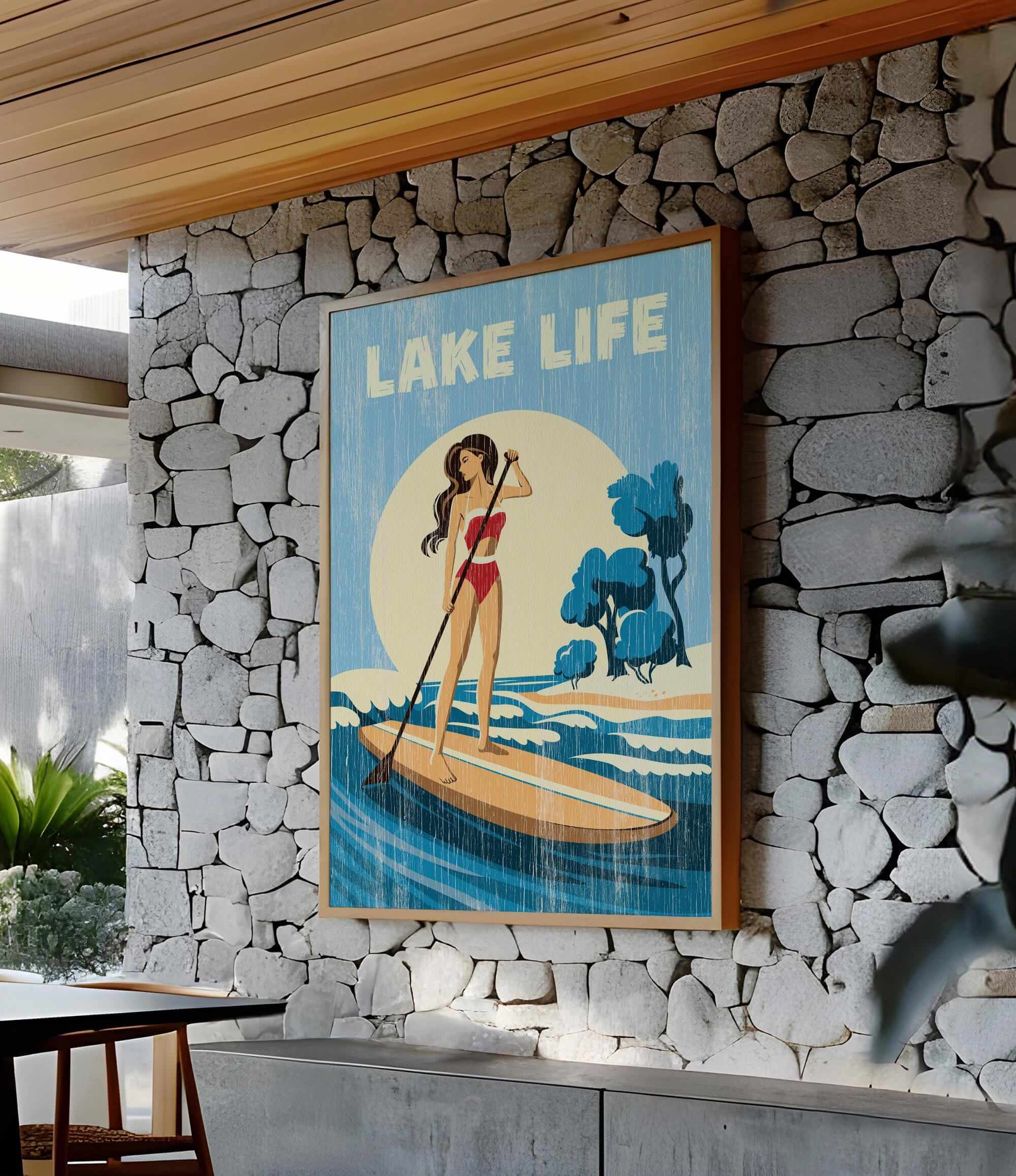A framed poster of a woman paddleboarding on a lake, with the text "LAKELIFE" prominently displayed.