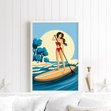 A framed illustration of a woman paddleboarding on a calm body of water, with a blue sky and trees in the background.