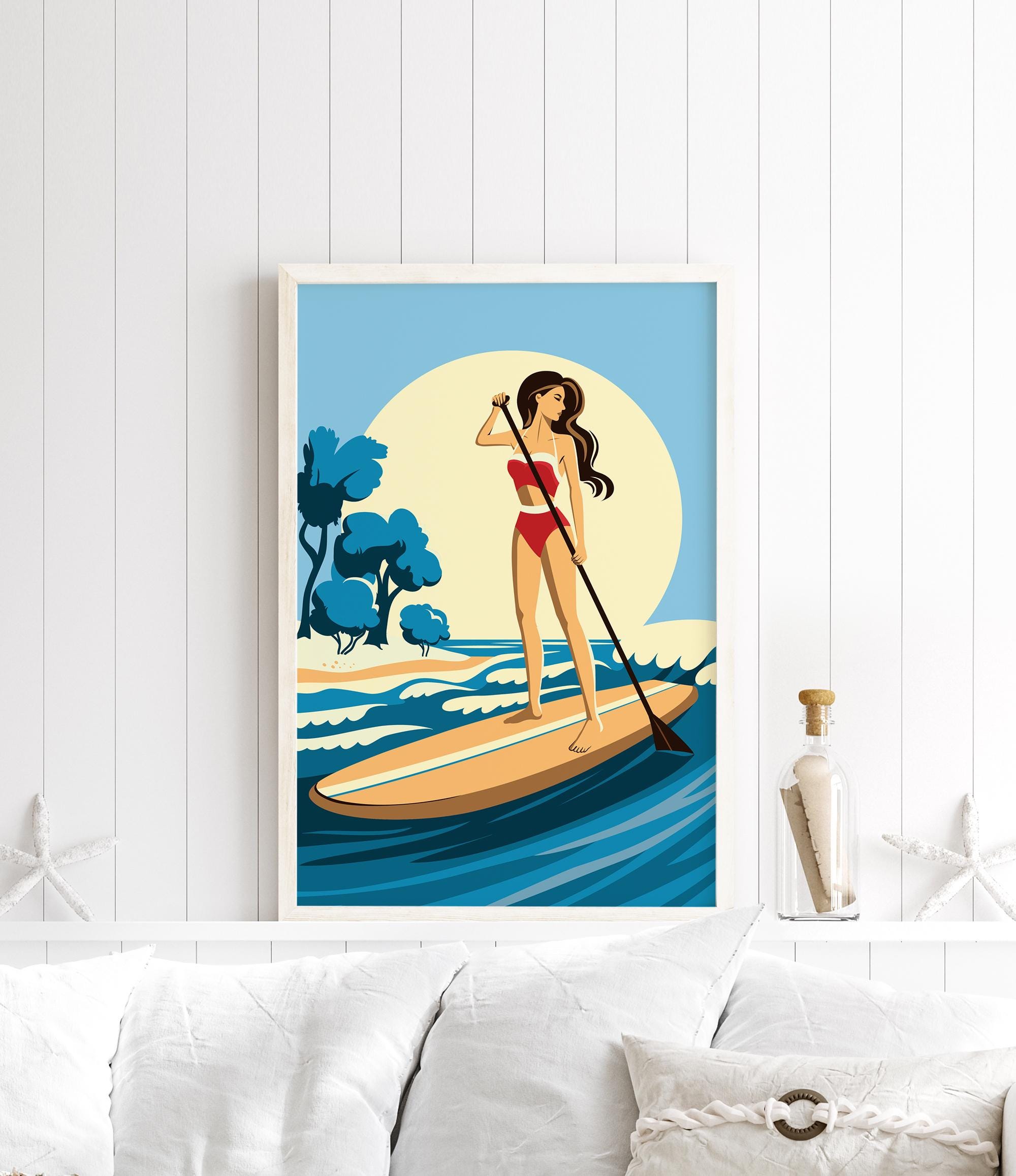 A framed illustration of a woman paddleboarding on a calm body of water, with a blue sky and trees in the background.