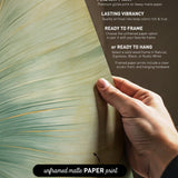 The image is a hand holding a piece of paper with text and a graphic of a leaf.