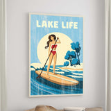 The image is a framed poster depicting a woman paddleboarding on a lake, with the text "LAKELIFE" prominently displayed.