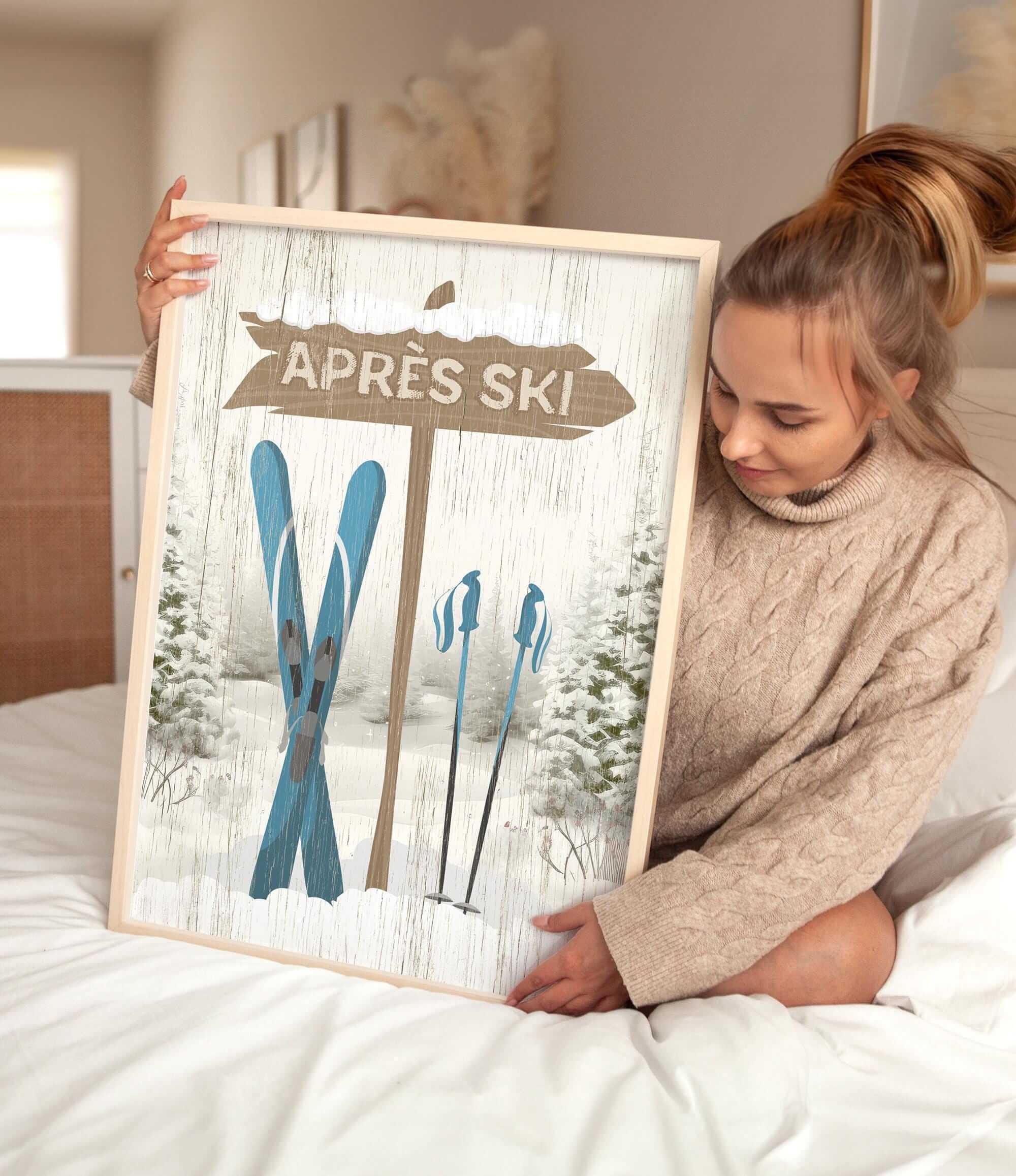 A woman sits on a bed holding the Cerulean Après Ski Signpost Wall Art—an ideal mountain lodge decor piece or vintage-inspired ski sign for your home.