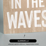 a wooden sign that says in the waves