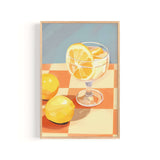 A framed illustration of a glass of lemonade with lemon slices, set on a checkered tablecloth.