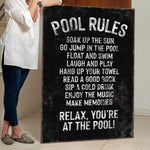a woman standing next to a pool rules sign
