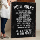 a woman standing next to a pool rules sign