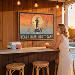 A woman stands at a bar with a framed poster of a paddleboarder and the text "BEACH HAIR, DON'T CARE" above it.