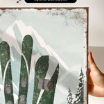 a person holding up a poster with skis on it
