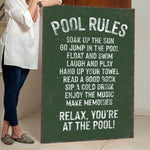 a woman standing next to a pool rules sign