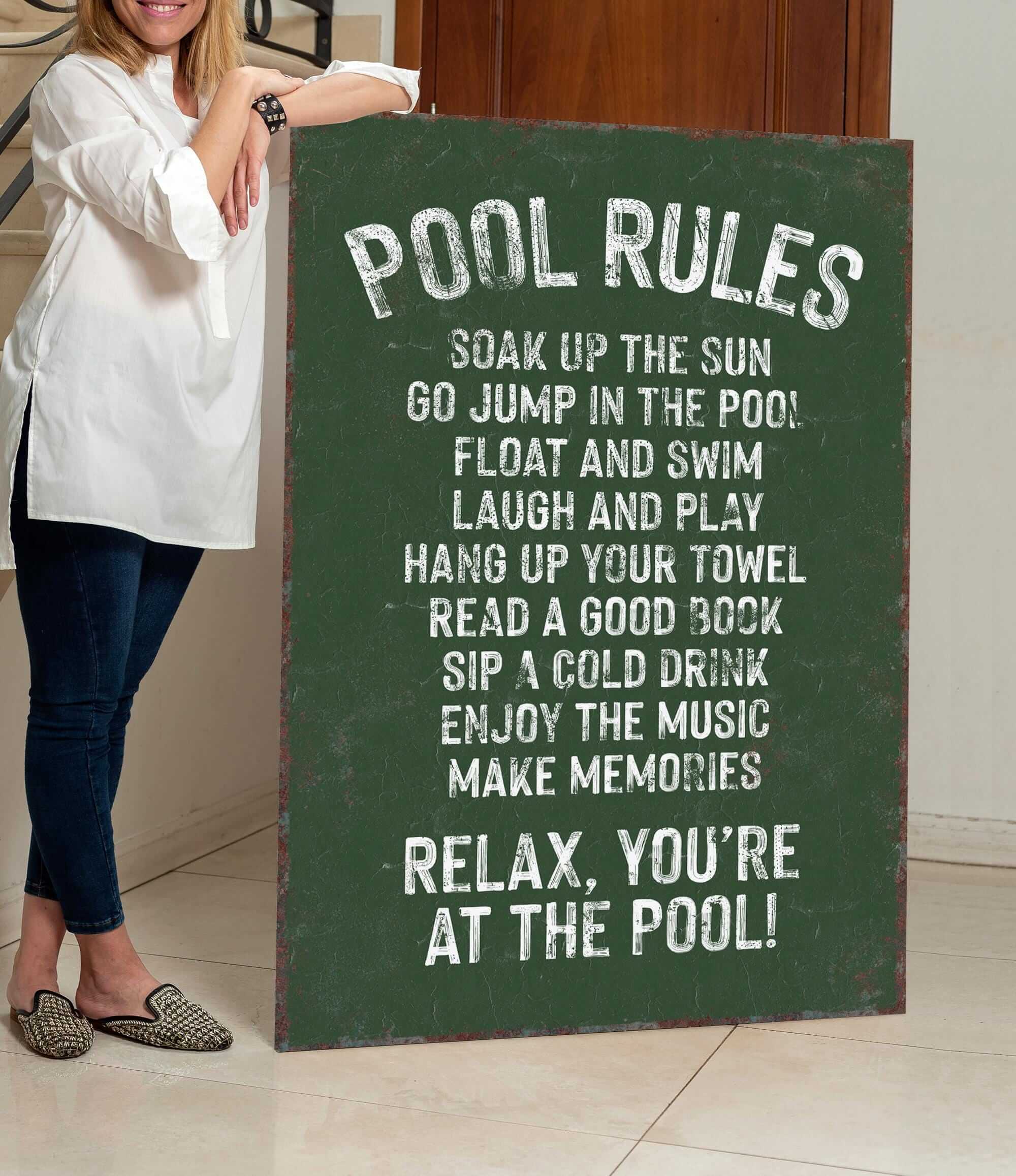 a woman standing next to a pool rules sign
