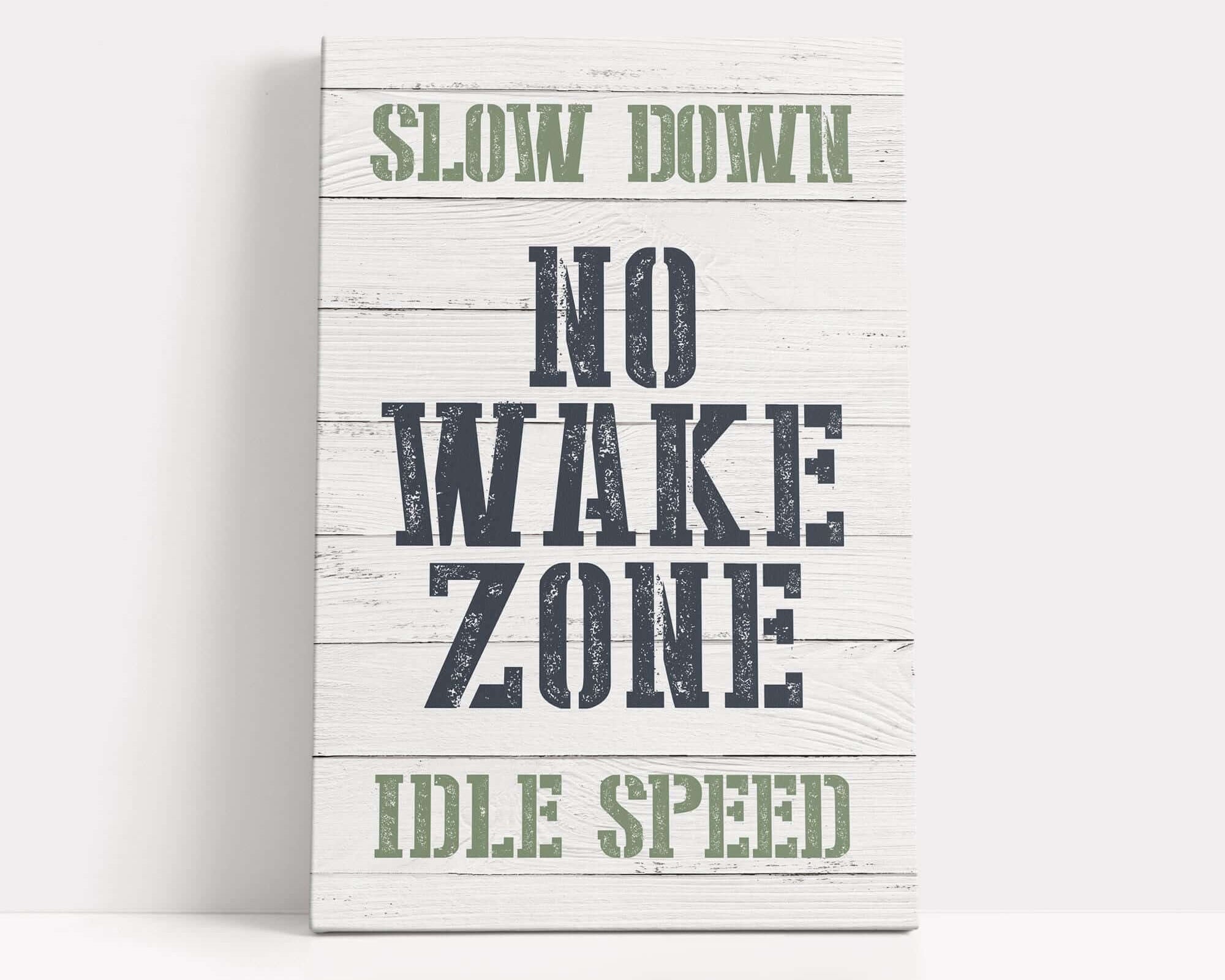 a wooden sign that says slow down no wake zone