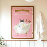 A framed poster with a cat sitting in a bathtub, surrounded by bubbles, and a towel hanging on the wall.