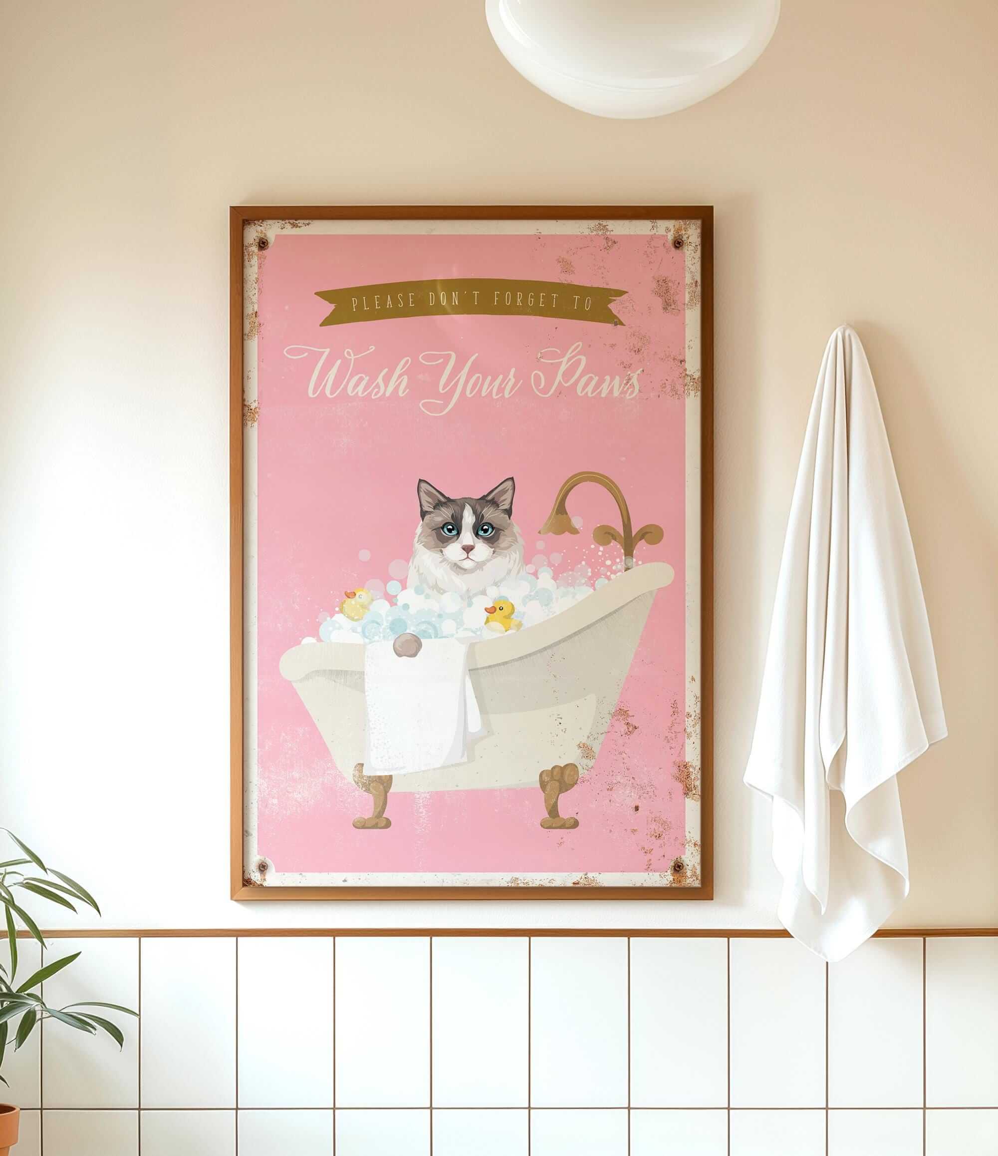 A framed poster with a cat sitting in a bathtub, surrounded by bubbles, and a towel hanging on the wall.