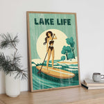a framed poster of a woman paddleboarding on a lake, with the text "LAKELIFE" prominently displayed.