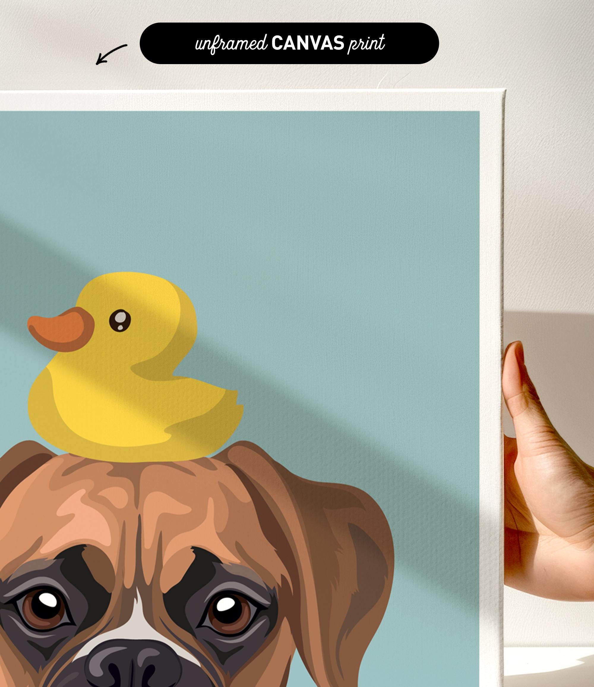 A hand is holding a framed print featuring a cartoon image of a dog with a yellow rubber duck on its head.