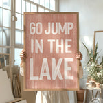 a person holding a sign that says go jump in the lake