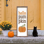 a black cat sitting next to a sign that says hello pumpkin